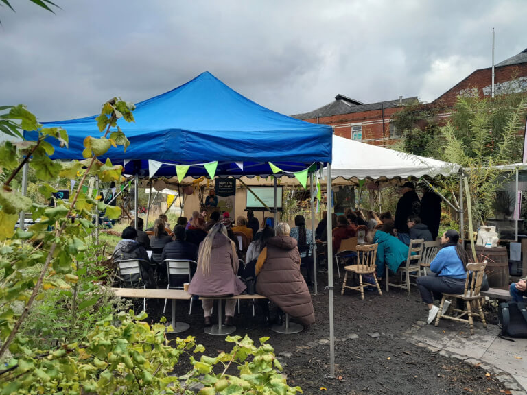 Gazebo with bunting sheltering people at community event