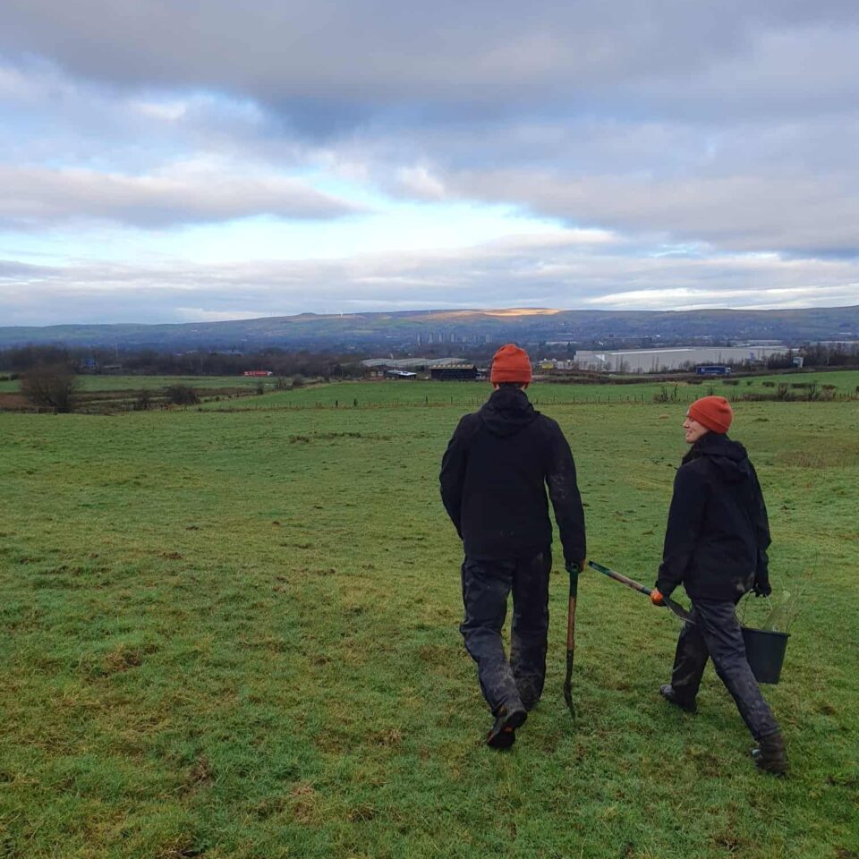 Two members of City of Trees team walking with beanies