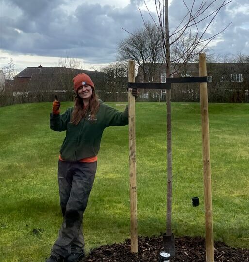 Woman standing smiling with tree