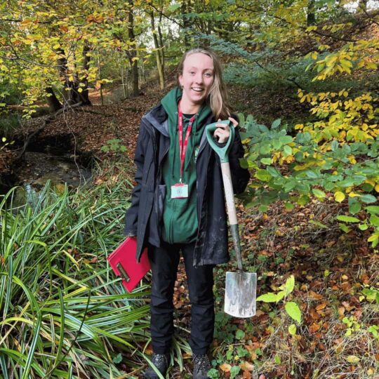 Member of team Grace, holding a spade and smiling