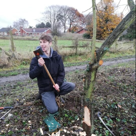 Member of staff kneeling down holding tools